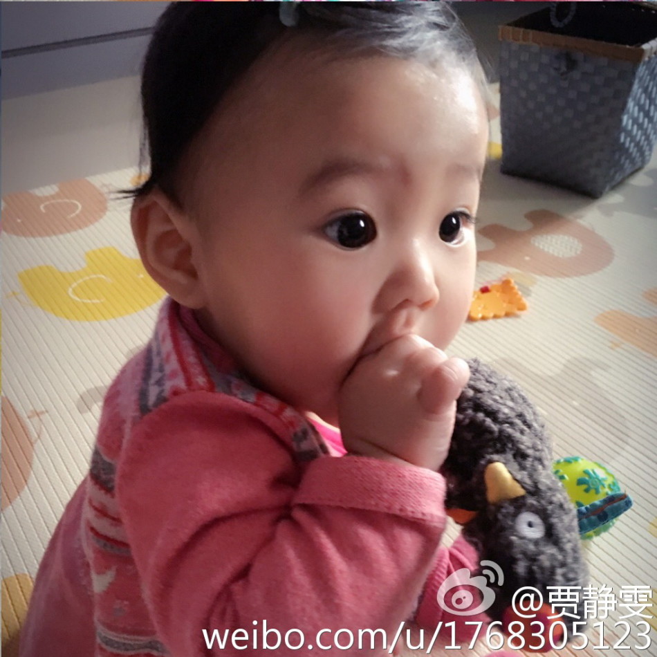 贾静雯在微博上晒出女儿大眼萌照，自曝女儿咘咘长牙发烧要抱抱，老公修杰楷半边肩膀实力出镜，一家人十分幸福。