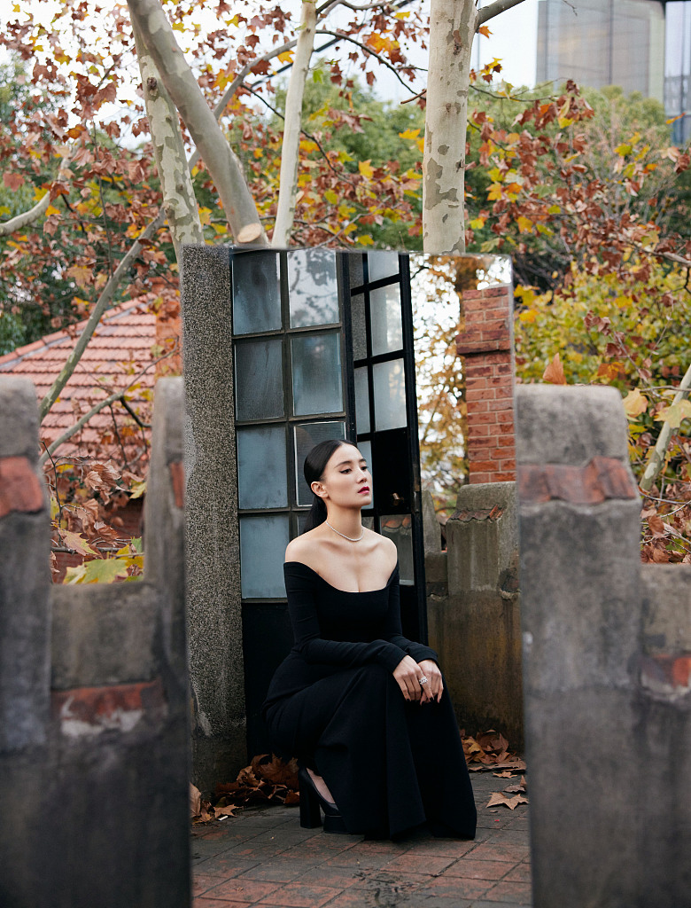 身穿一字肩暗黑礼服裙，勾勒出完美身材，搭配黑色厚底玛丽珍鞋复古又神秘。